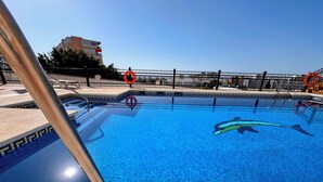 A swimming pool with a dolphin mosaic, a lifebuoy, and a fence. - Sea-view apartment in Torremolinos, a 10-minute walk to the beach (Torremolinos)