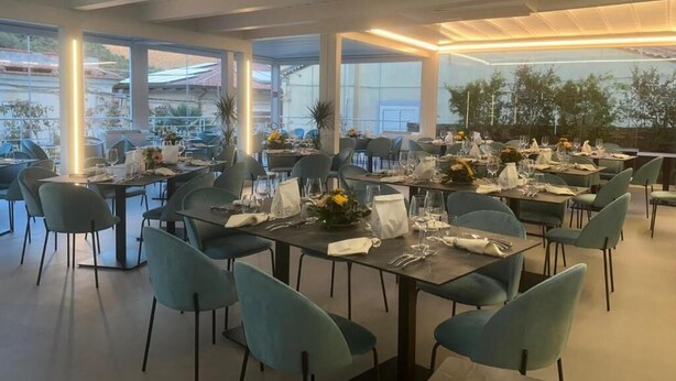 Un restaurante con varias mesas, sillas y vistas al exterior.