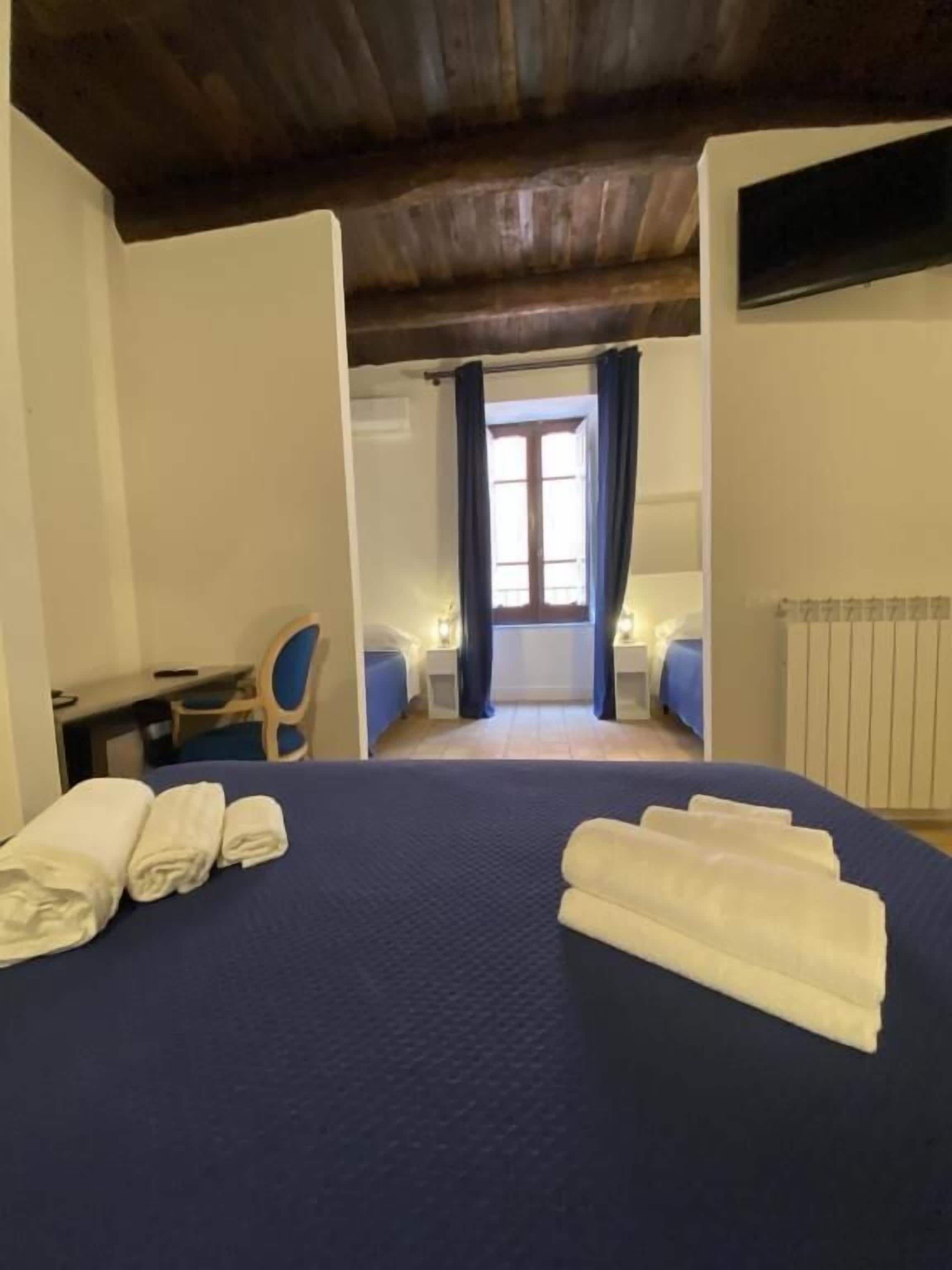 A hotel room with a bed, a desk, and a chair.