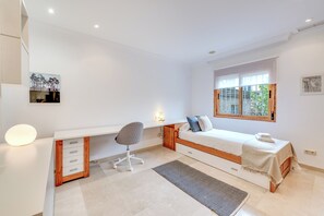 A modern bedroom with a bed, desk, chair, and a window with a view. - LXR Villa Mirador del Sur, 5 Bedrooms, Ocean Views (Marbella)