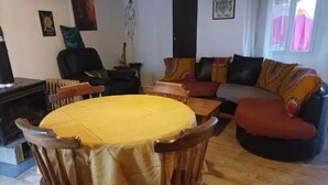 Un salon chaleureux avec une table ronde en bois, un canapé et une cheminée.