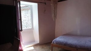 Une pièce avec un lit, une fenêtre et une porte.