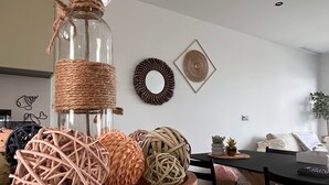 Un tavolo da pranzo con un vaso di fiori, cesti intrecciati e decorazioni a parete.