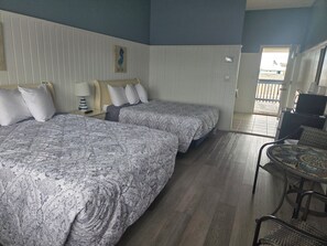 A hotel room with two beds, a small table, and a chair. - Cozy 1-bedroom hotel in beautiful Point Pleasant Beach (Point Pleasant Beach)