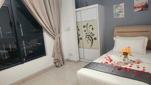 Ein Schlafzimmer mit Bett, einem Fenster mit Vorhängen, einem Kleiderschrank und zwei Wandbildern.