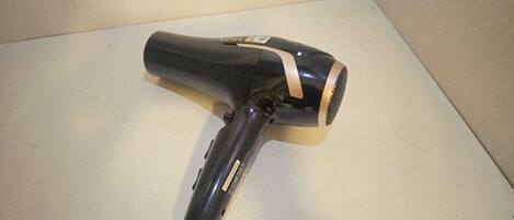 A hair dryer on a white surface.