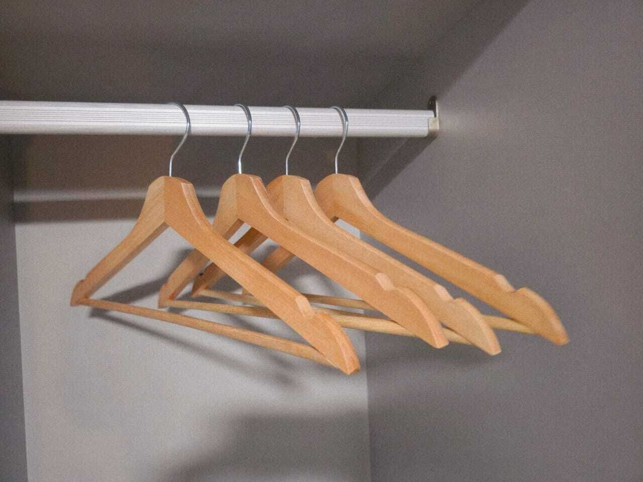 Una barra de metal con perchas de madera.