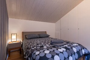 A bedroom with a bed, a bedside table with a lamp, and a wardrobe. - Kizuna Chalet - Enjoy the view of Mont Blanc and the hot tub (Saint-Gervais-les-Bains)