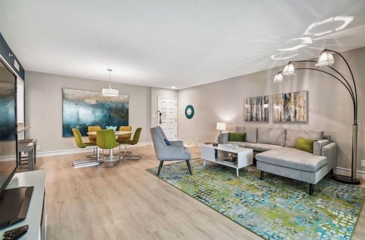 A modern living room with a dining area, a sofa, a coffee table, and a floor lamp.