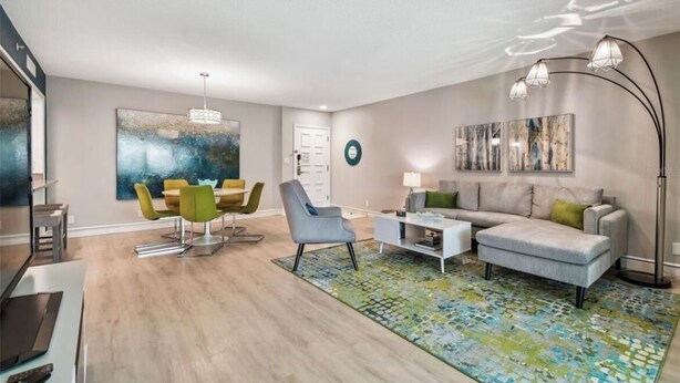 Un salon moderne comprenant un coin repas, un canapé, une table basse et un lampadaire.
