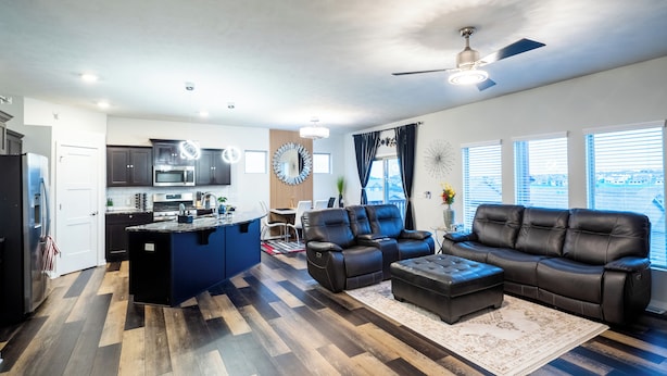 Un espacio de estar moderno con cocina, comedor y zona de descanso.