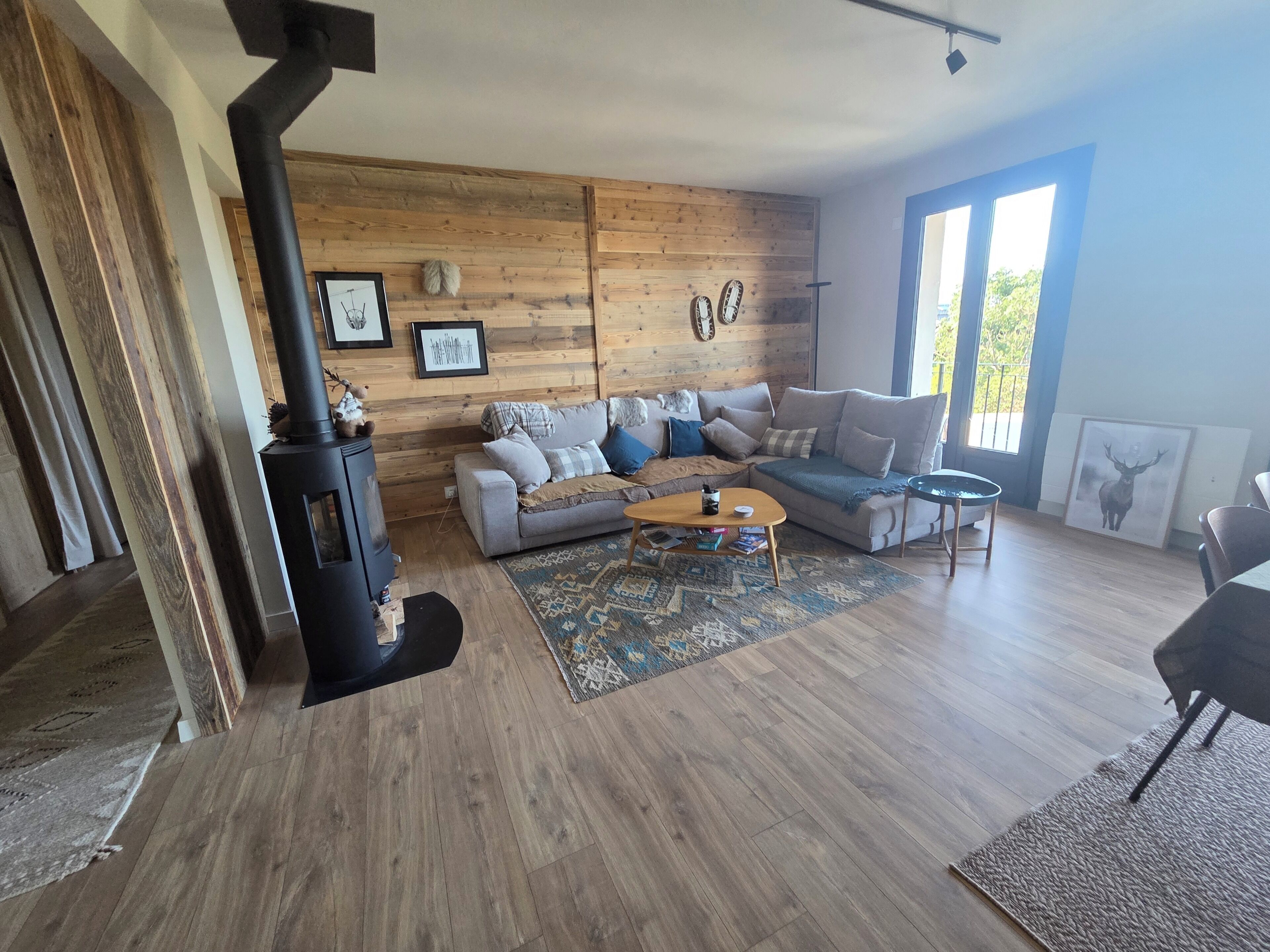 A living room with a sofa, a coffee table, a fireplace, and a large window.