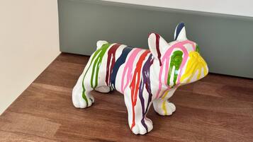 Eine bunte Hundfigur auf einer Holztischplatte.
