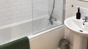 A bathroom with a glass-enclosed shower, a white sink, and a mirror. - Spacious 2 Bed apartment Rainham LDN Gated Parking (Greater London)
