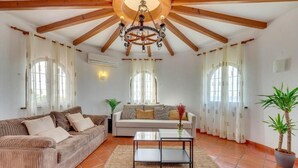 A living room with a sofa, a coffee table, and a chandelier. - LXR Villa Sirena Oceanfront 3-Bedroom (El Faro)
