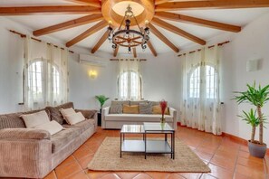 Ein Wohnzimmer mit einer Couch, einem Couchtisch und einer Chandelier.