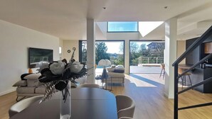 Un intérieur moderne comprenant un coin repas, un canapé et un escalier.