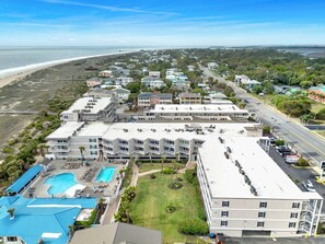 Een kusthotel met meerdere gebouwen, een zwembad en uitzicht op het strand.