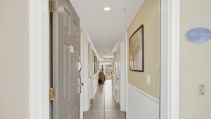A hallway with white doors, beige walls, and a sign reading 'GULL REEF 634'. - Ocean‑View Condo in Beachside Colony • Pools • Steps to the Sand • Restaurant (Tybee Island)