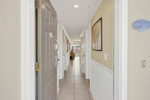 A hallway with white doors, beige walls, and a sign reading 'GULL REEF 634'. - Ocean‑View Condo in Beachside Colony • Pools • Steps to the Sand • Restaurant (Tybee Island)