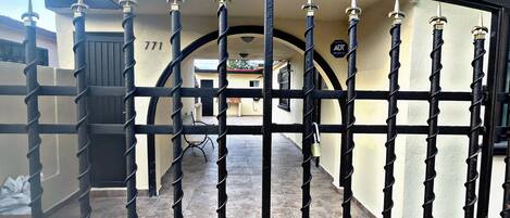 A gated entrance with a spiral staircase leading to a covered area.