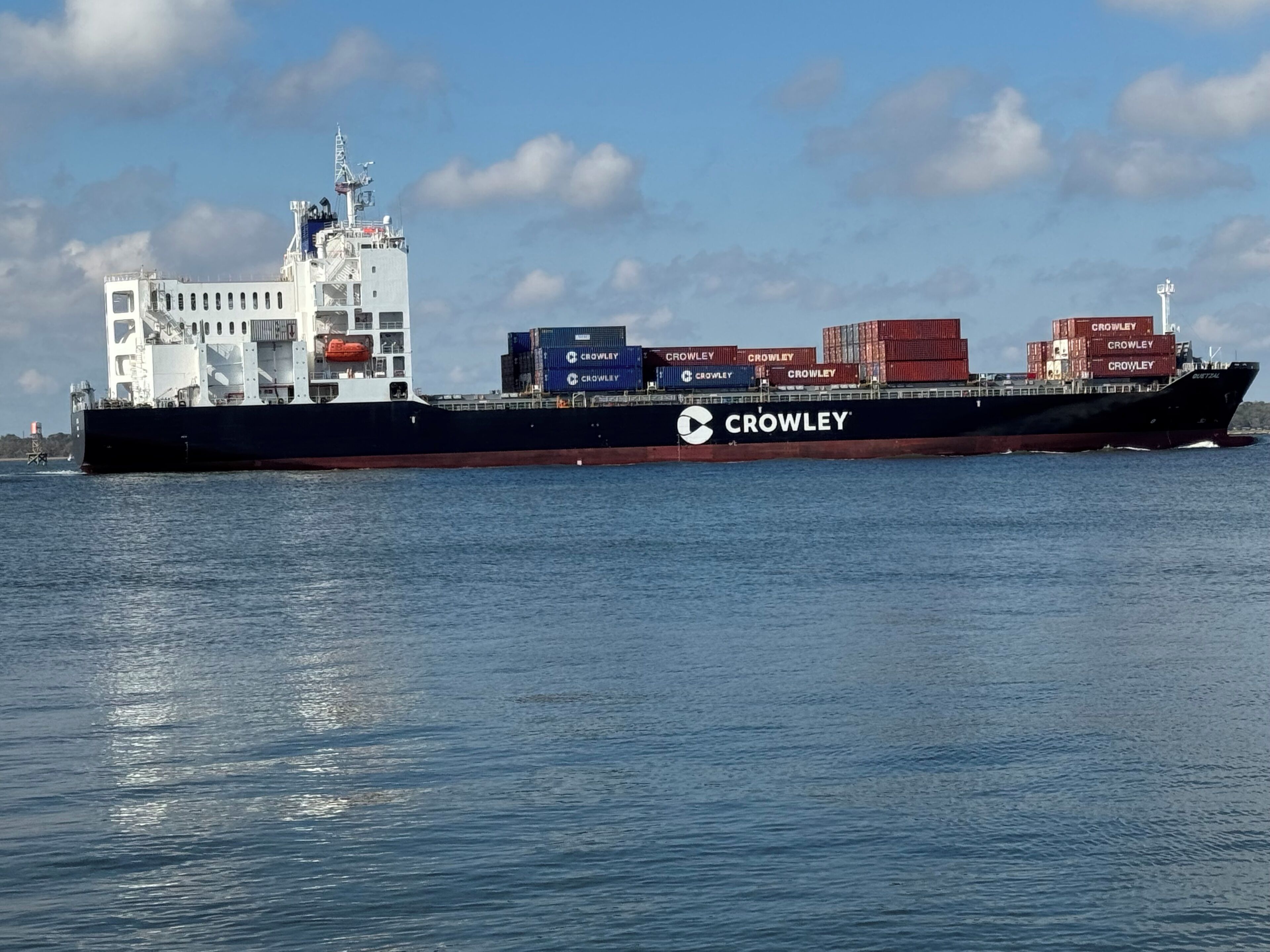 Una grande nave cargo con il nome 'CROWLEY' sullo scafo, che naviga sull'acqua.