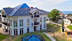Ein mehrstöckiges Haus mit einem markanten, blauen Dach und großen Fenstern sowie einem Balkon.