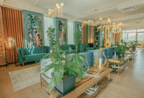 A modern living room with teal sofas, a wooden coffee table, and potted plants.