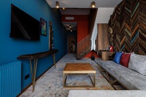 Una sala de estar moderna con sofá, mesa de centro y televisor.