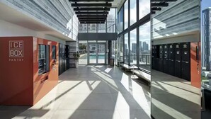 Un edificio moderno con facciata in vetro, un cartello rosso con la scritta 'ICE BOX PANTRY' e vista sulla città.
