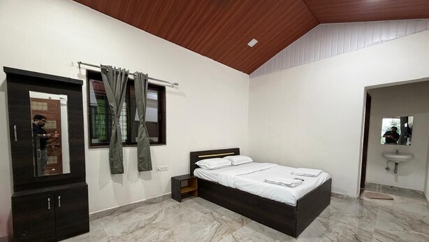 Un dormitorio con cama, armario, espejo y baño con lavamanos.