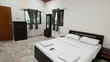 A bedroom with a bed, a wardrobe, a ceiling fan, and a window with curtains.