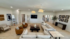 A spacious living room with a sofa set, a coffee table, and a TV. - Lakeview Hideaway - Sleeps 14 - Family Retreat (Spirit Lake)