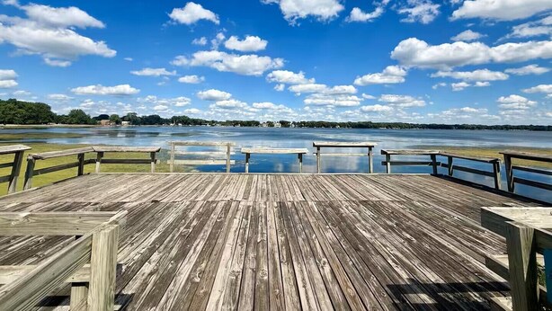 A wooden deck with benches overlooking a body of water and a distant shoreline. - Lakeview Hideaway - Sleeps 14 - Family Retreat (Spirit Lake)