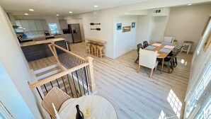 A spacious living area with a kitchen, dining area, and a staircase. - Lakeview Hideaway - Sleeps 14 - Family Retreat (Spirit Lake)
