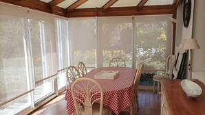 A covered patio with a table set for four, surrounded by wicker chairs, and a wooden counter to the side. - House, pets allowed - 6 guests, 100m from the sea (Le Croisic)