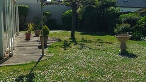A garden with potted plants, a wooden deck, and a house with a sloped roof. - House, pets allowed - 6 guests, 100m from the sea (Le Croisic)