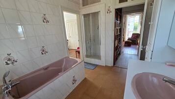 Ein Badezimmer mit einer Badewanne, einem Waschbecken und einer Dusche.
