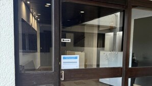 Ingresso con porta in vetro e cartello che indica una proprietà condominiale.
