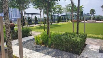 A landscaped garden with pathways, trees, and a grassy area.