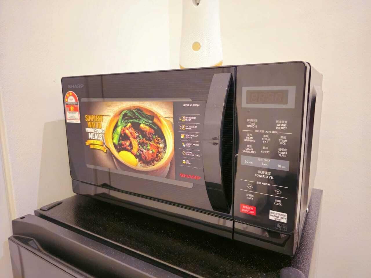 A microwave with a digital display, a power level indicator, and a clock.