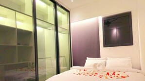 A hotel room with a bed, a large sliding glass door, and a wall-mounted clock. - Equine Residence - Seri Kembangan (Seri Kembangan)