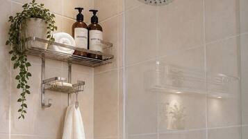 A shower with a handheld showerhead and a wall-mounted faucet.