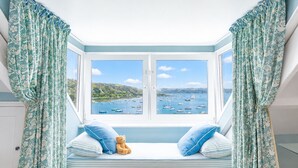 A bay window with a view of boats, a teddy bear, and striped pillows. - Falmouth's Finest  - Chy En Glas (Falmouth)