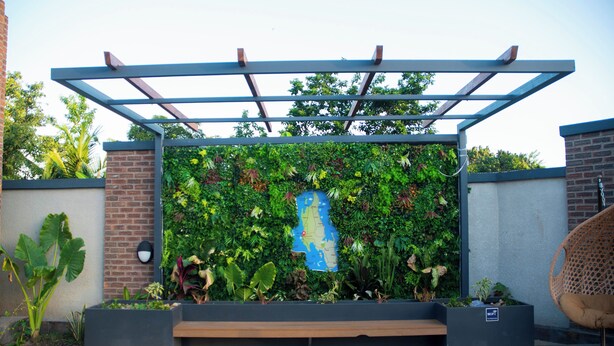 A garden with a wooden bench, a map, and a pergola structure.