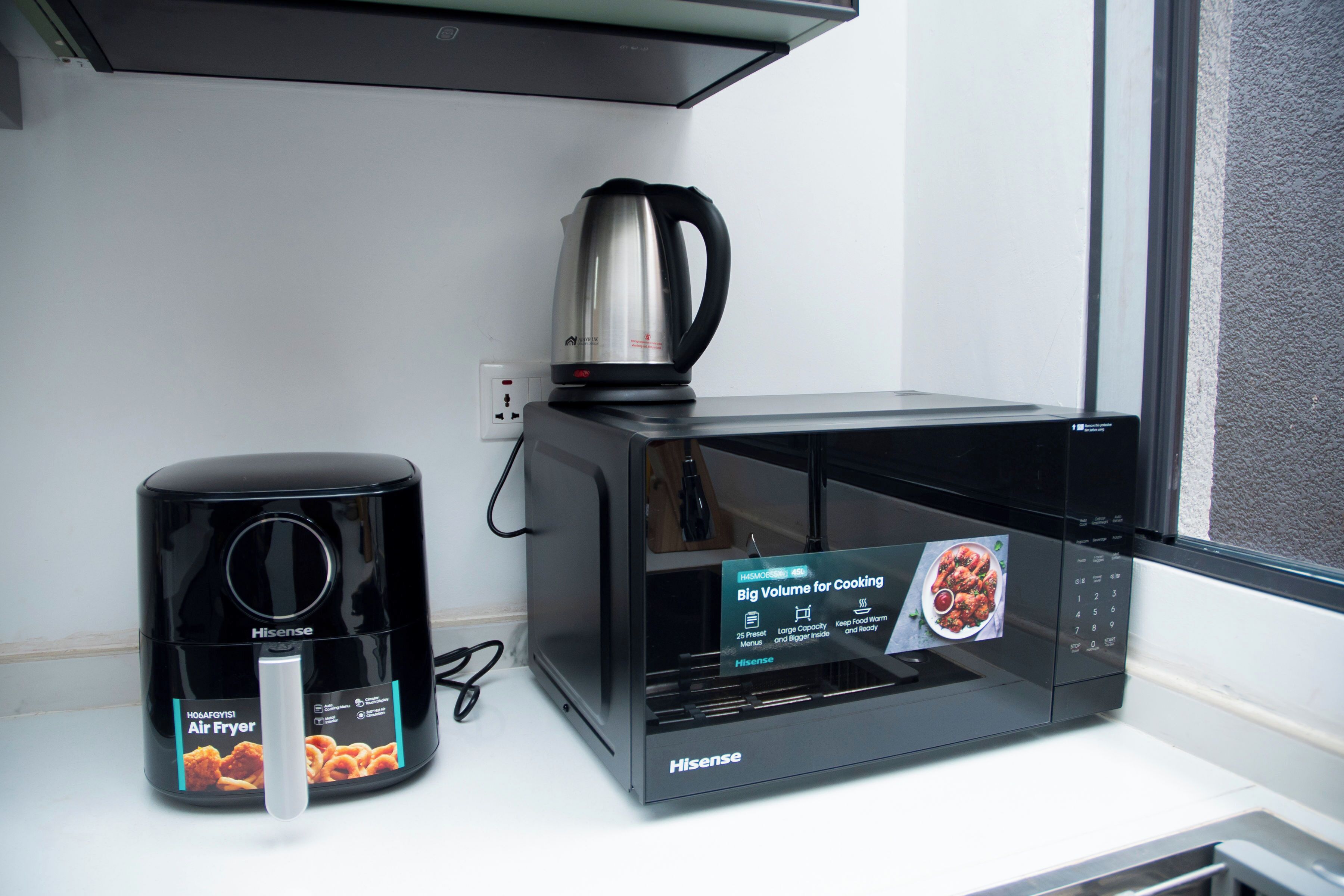 A Hisense air fryer and a microwave on a white countertop.