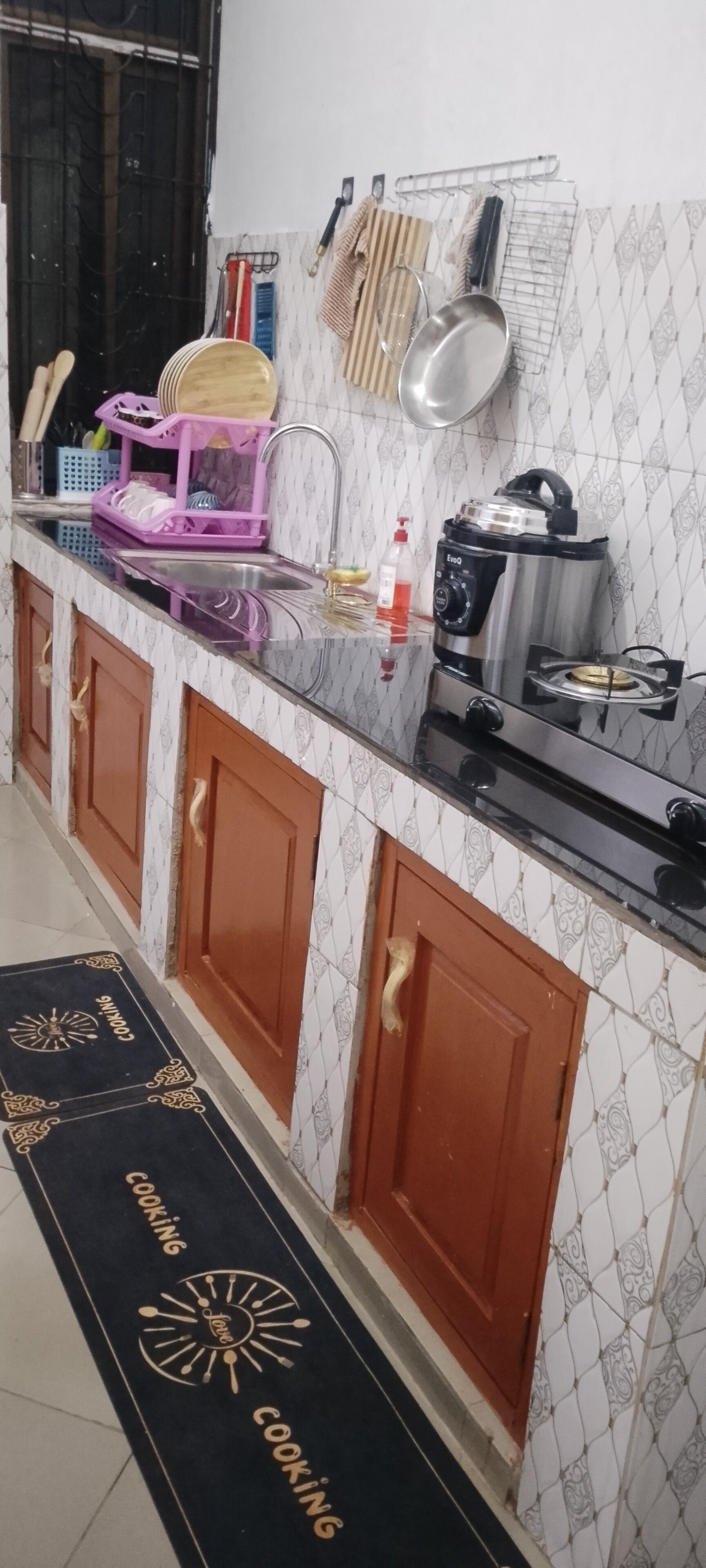 A kitchen with wooden cabinets, a countertop, and a backsplash.