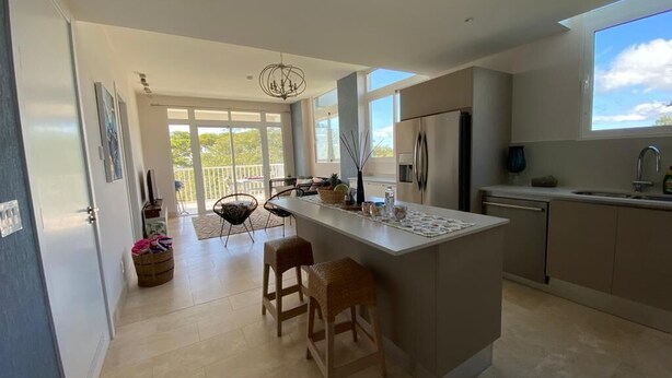 Una cocina moderna con una isla central, ventanas amplias y vistas al exterior.