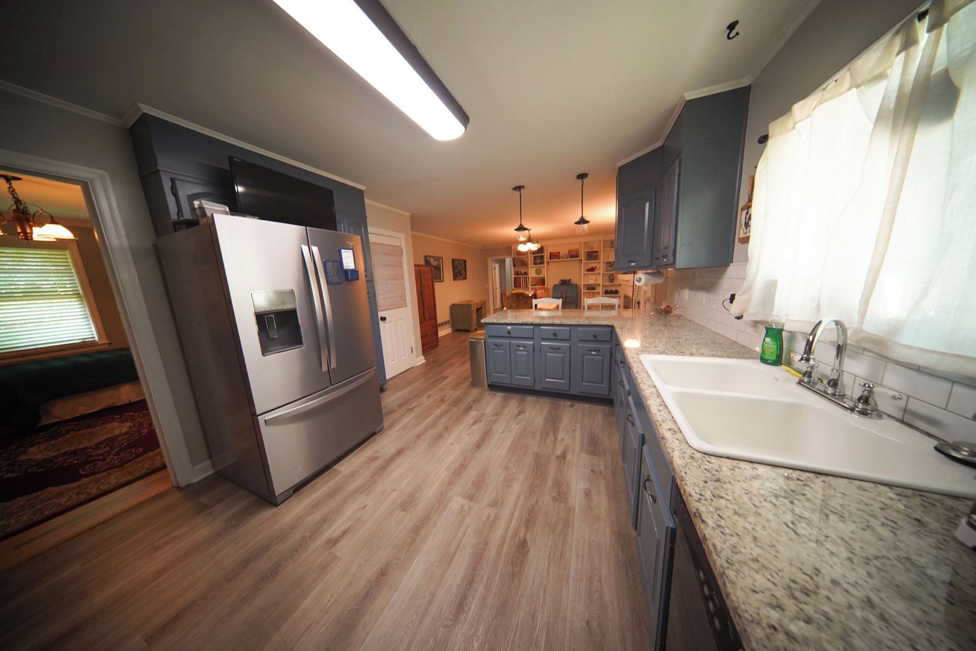 A modern kitchen with a built-in refrigerator, granite countertops, and a large island with a sink.