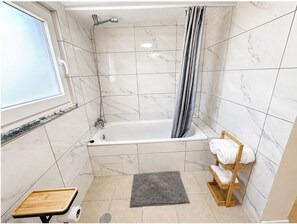Een douche, handdoeken, zeep, toiletpapier